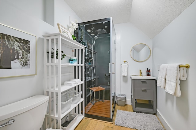 full bath with lofted ceiling, toilet, wood finished floors, a textured ceiling, and a stall shower