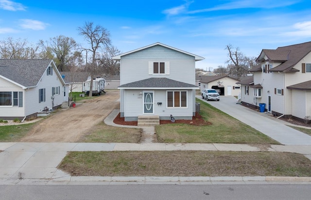 view of front facade featuring driveway, a residential view, and a front yard