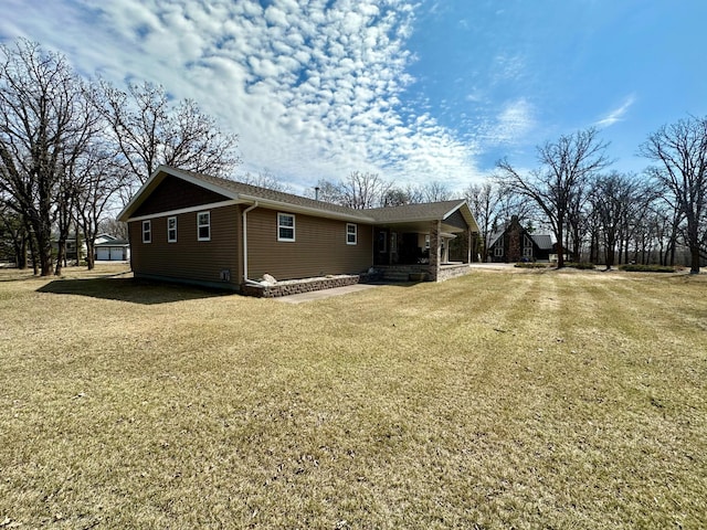 back of property featuring a porch and a yard