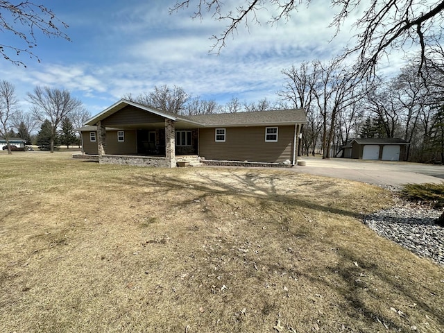 view of front facade with an outdoor structure, stone siding, concrete driveway, and covered porch