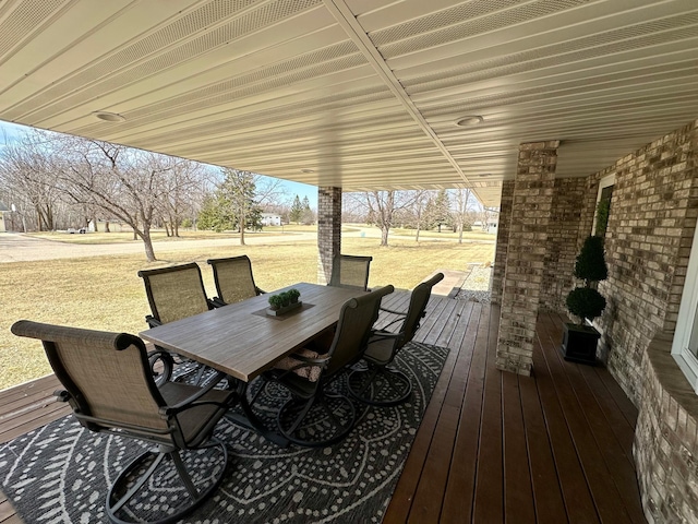 deck with outdoor dining space and a lawn