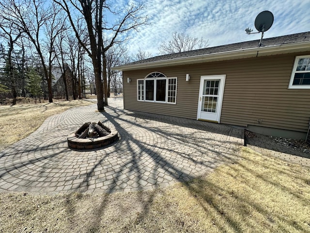 back of property featuring a fire pit and a patio