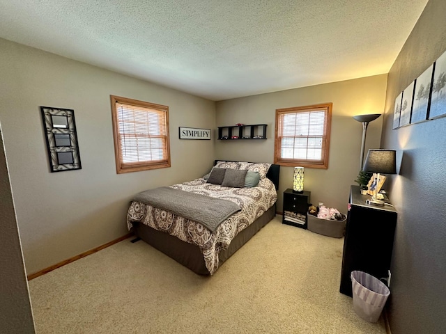 carpeted bedroom featuring baseboards and a textured ceiling