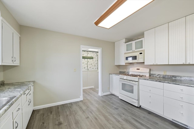 kitchen with light wood finished floors, baseboards, white cabinetry, and white appliances