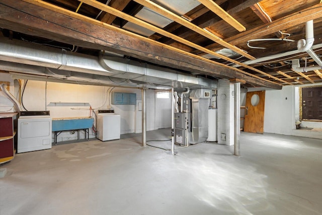 below grade area featuring washer / clothes dryer, heating unit, and a sink