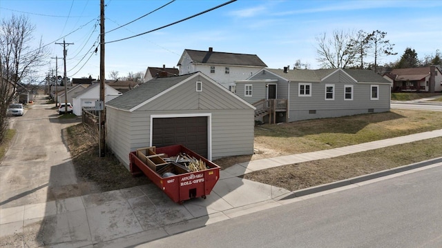 view of front facade featuring a garage, an outdoor structure, a front lawn, and crawl space