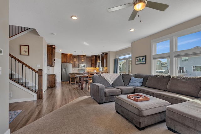 living room with ceiling fan, light wood-style flooring, recessed lighting, and stairway