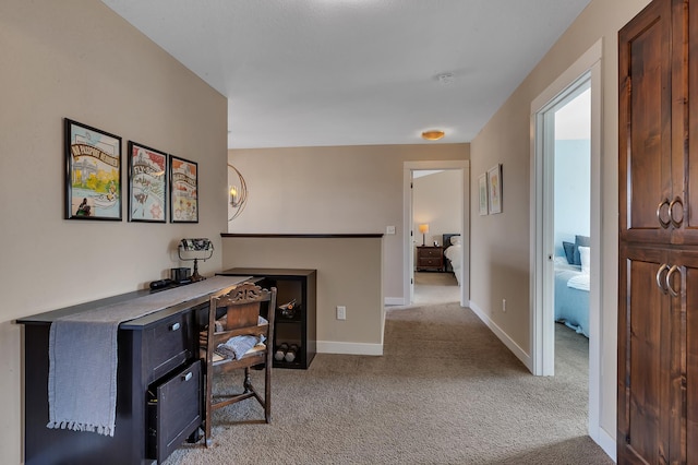 office space featuring baseboards and light colored carpet