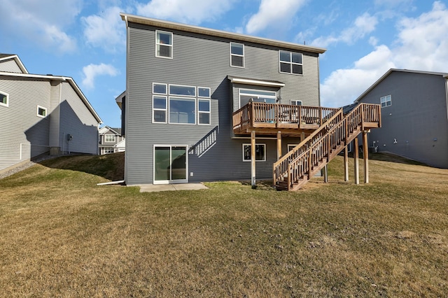 rear view of house with a yard, a deck, and stairs