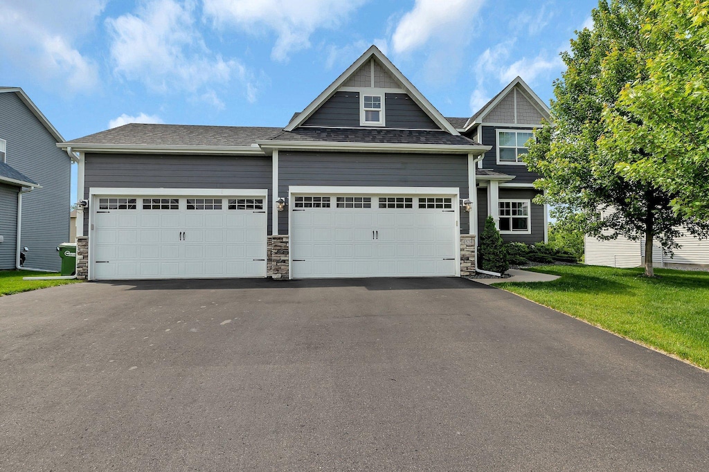 4524 121st Ct NE, Blaine, MN 55449 - view of front facade with driveway, a garage, and stone siding