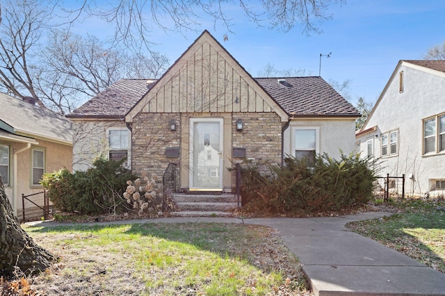 view of front of property with roof with shingles, stucco siding, stone siding, and fence