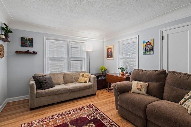 living area featuring light wood-type flooring and a textured ceiling