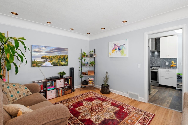 living room with light wood-type flooring, recessed lighting, baseboards, and visible vents