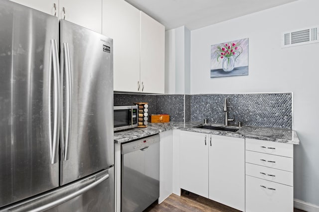kitchen featuring visible vents, white cabinetry, light stone counters, a sink, and stainless steel appliances