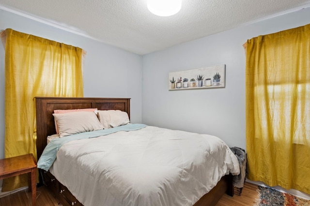 bedroom featuring a textured ceiling and wood finished floors