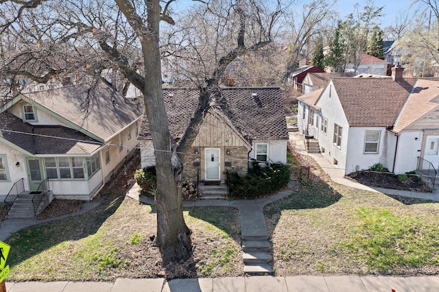 view of front of home featuring a sunroom, a front lawn, a residential view, and entry steps