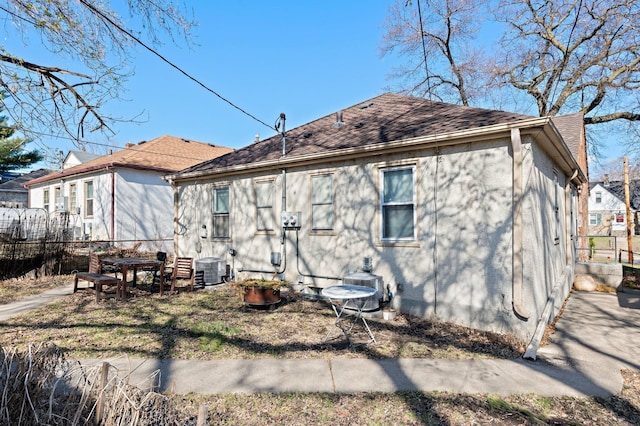 46324634 Cedar Ave S, Minneapolis, MN 55407 - back of property featuring fence, central AC unit, stucco siding, and roof with shingles