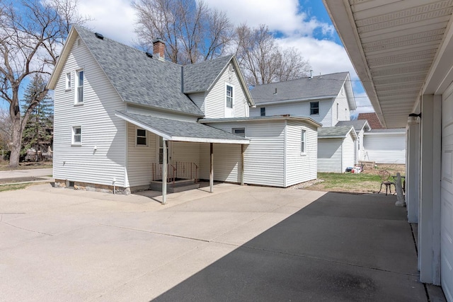 1509 5th St, Mankato, MN 56001 - rear view of house featuring a chimney, roof with shingles, and a patio