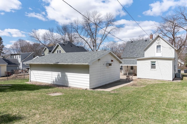 1509 5th St, Mankato, MN 56001 - back of property with a patio area, a shingled roof, an outbuilding, and a yard