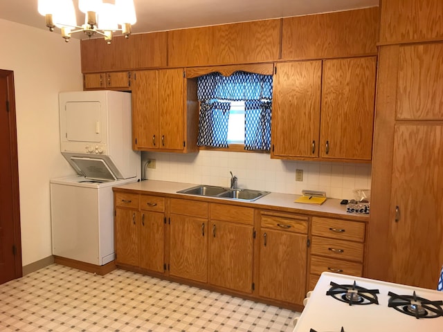 1509 5th St, Mankato, MN 56001 - kitchen with stacked washer and clothes dryer, light countertops, an inviting chandelier, and a sink