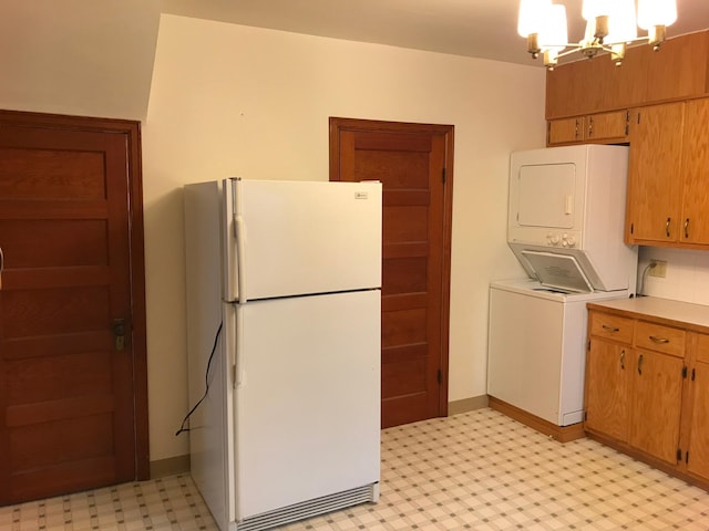 1509 5th St, Mankato, MN 56001 - kitchen with light floors, an inviting chandelier, stacked washer / dryer, and freestanding refrigerator