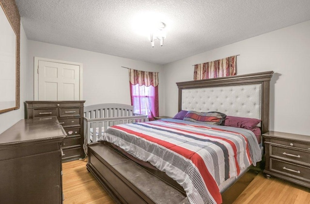 bedroom featuring a textured ceiling and light wood finished floors
