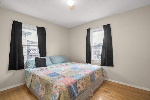 bedroom with wood finished floors and baseboards