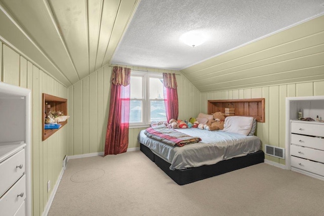 carpeted bedroom with lofted ceiling, baseboards, and visible vents