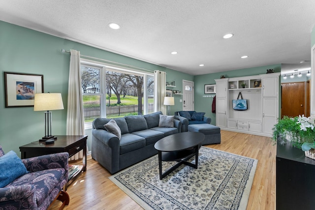 living area featuring light wood-style floors, recessed lighting, and a textured ceiling