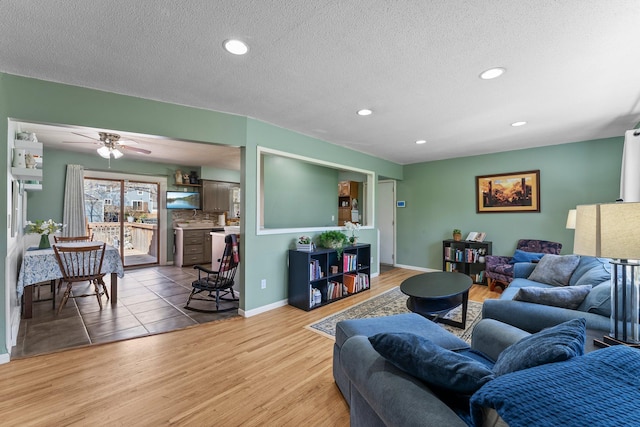 living room with recessed lighting, ceiling fan, wood finished floors, and a textured ceiling