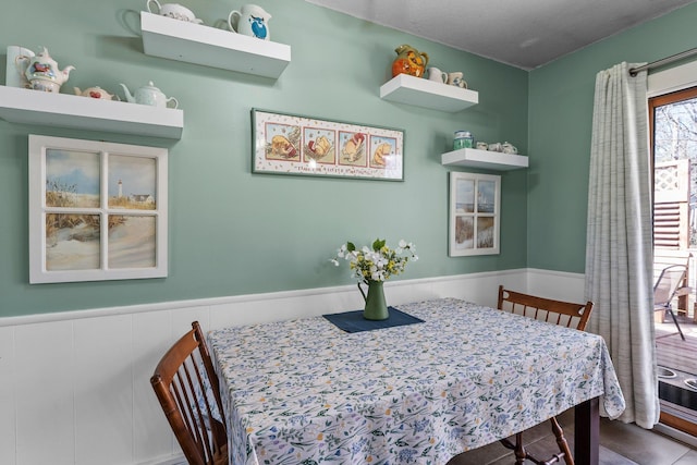 dining space with a wainscoted wall