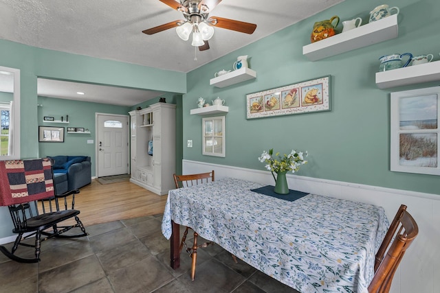 dining space with a ceiling fan and a textured ceiling