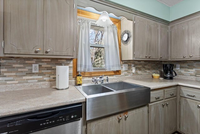 kitchen featuring stainless steel dishwasher, light countertops, a sink, backsplash, and gray cabinetry