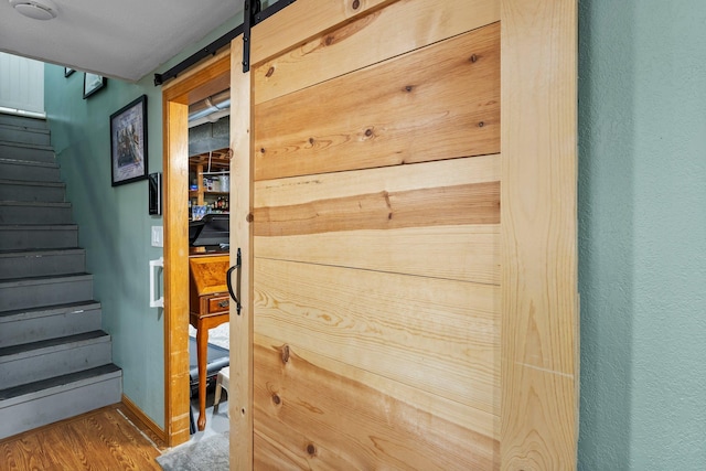 details with a barn door and wood finished floors