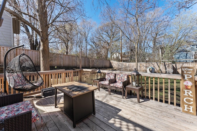 wooden terrace with a fenced backyard and an outdoor fire pit