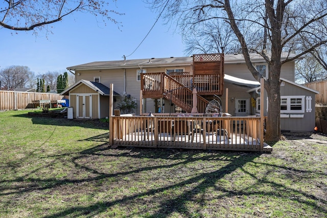 rear view of property featuring a yard, a deck, an outdoor structure, and a storage unit