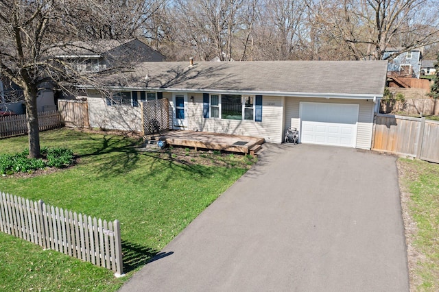 view of front facade featuring fence, an attached garage, driveway, and a front yard