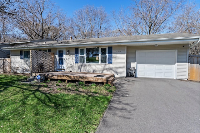 single story home featuring a garage, aphalt driveway, fence, a front yard, and a deck