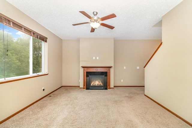 657 Golden Oak St NE, Lonsdale, MN 55046 - unfurnished living room with a glass covered fireplace, a ceiling fan, carpet, and a textured ceiling