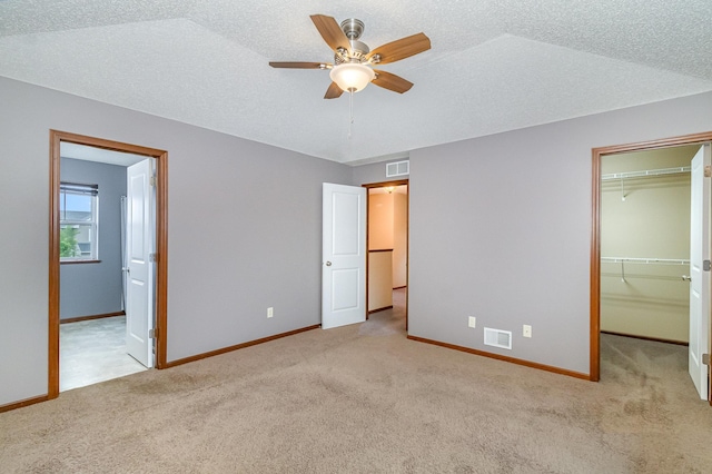 657 Golden Oak St NE, Lonsdale, MN 55046 - unfurnished bedroom with carpet, a walk in closet, a closet, a textured ceiling, and connected bathroom