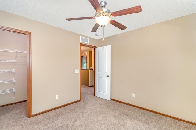 657 Golden Oak St NE, Lonsdale, MN 55046 - unfurnished bedroom with light colored carpet, a closet, a walk in closet, and a ceiling fan