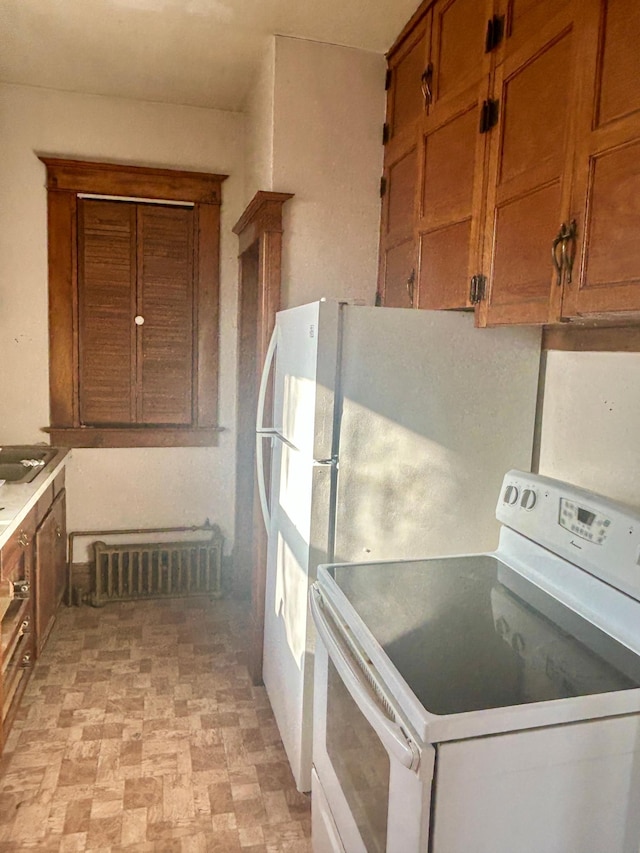 kitchen featuring white electric range oven, brown cabinets, visible vents, and light countertops