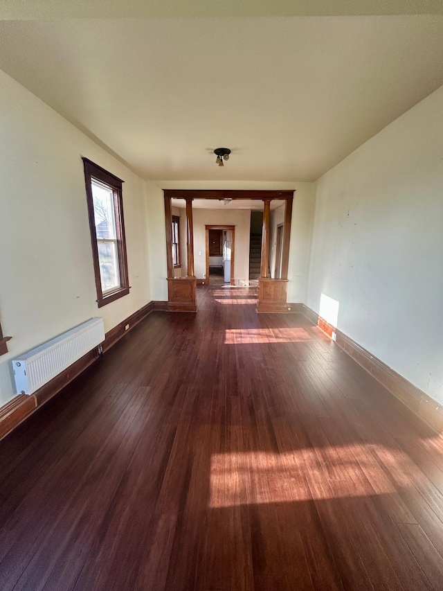 interior space with radiator, baseboards, and dark wood-style flooring
