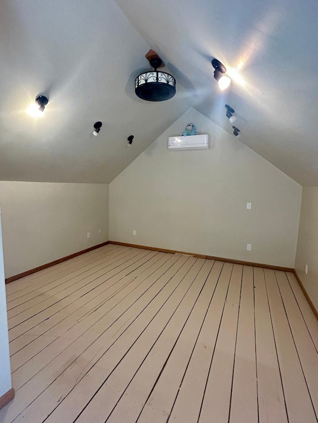 additional living space with vaulted ceiling, baseboards, and wood finished floors