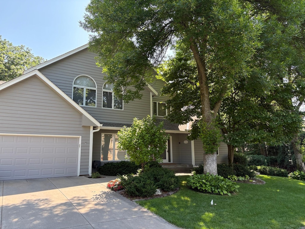11943 Orchard Ave W, Minnetonka, MN 55305 - view of front of property featuring driveway, a front lawn, and an attached garage