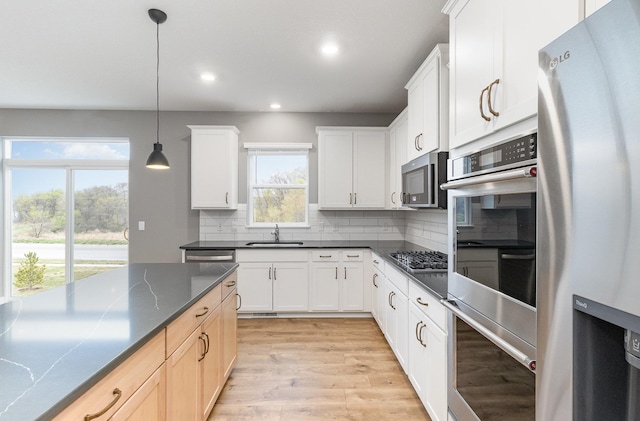 3088 Sunflower Way NW, Prior Lake, MN 55352 - kitchen featuring appliances with stainless steel finishes, a sink, recessed lighting, dark countertops, and backsplash