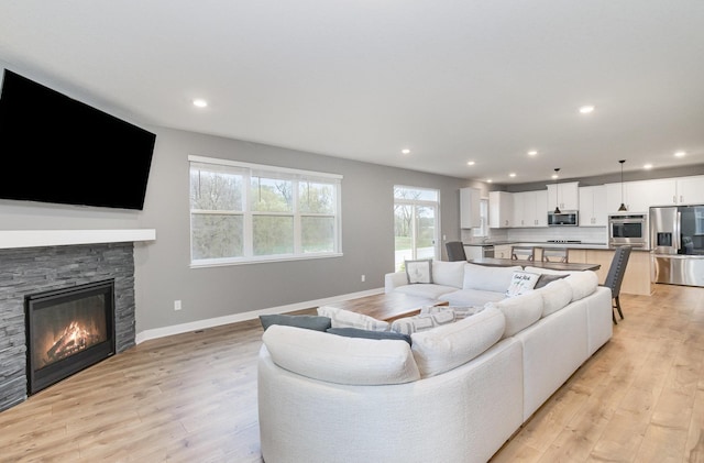 3088 Sunflower Way NW, Prior Lake, MN 55352 - living area featuring light wood-type flooring, recessed lighting, baseboards, and a stone fireplace