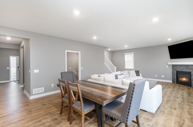 3088 Sunflower Way NW, Prior Lake, MN 55352 - dining room featuring light wood-type flooring, recessed lighting, a stone fireplace, stairway, and baseboards