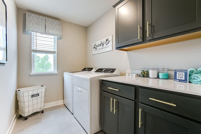 clothes washing area with baseboards, cabinet space, and washing machine and clothes dryer