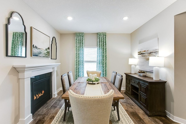 dining room with dark wood finished floors, baseboards, and recessed lighting
